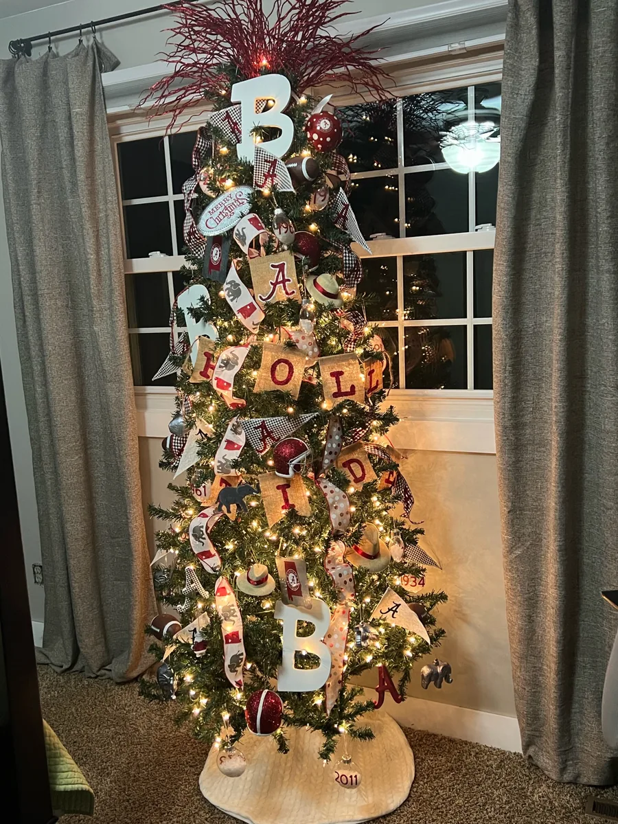 A collegiate crimson themed Christmas tree with letter and football ornaments.