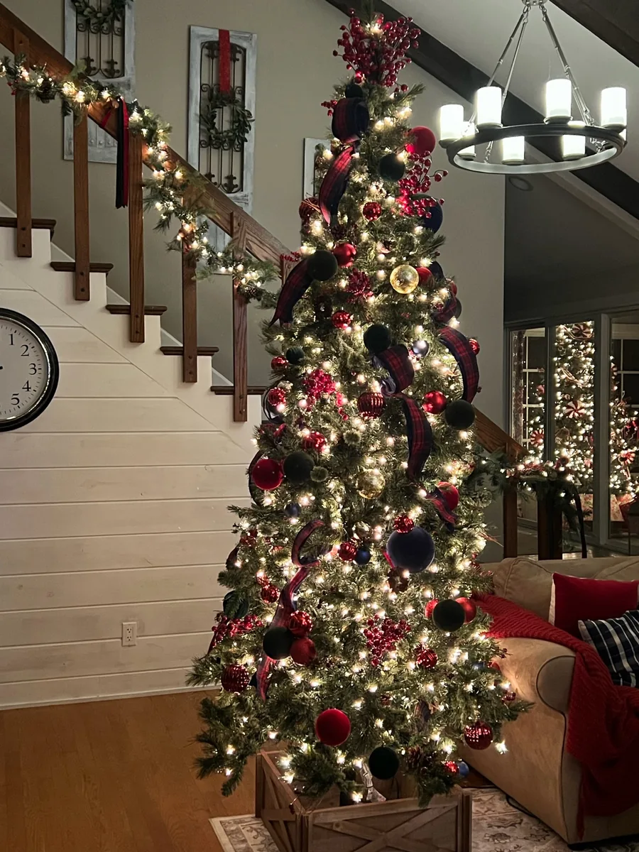 A large living-room tree uses oversized red, green, and plaid ornamentation.